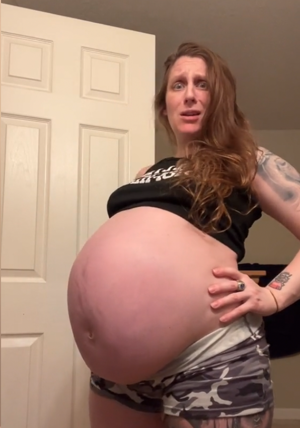 Eine schwangere Frau zeigt ihren Schwangerschaftsbauch