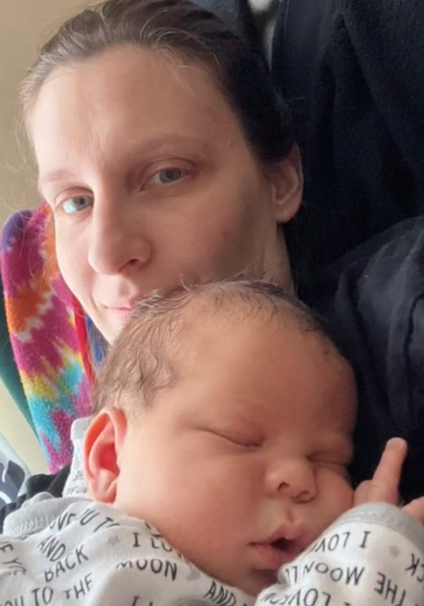 Frau hält ihr schlafendes Baby im Arm